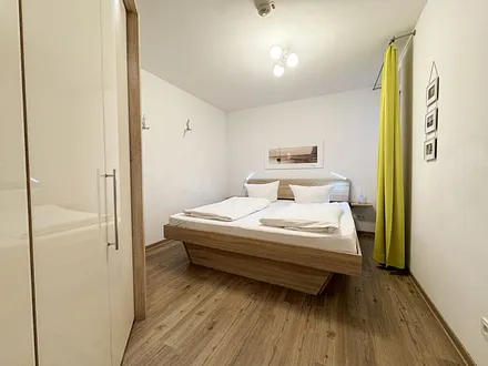 Schlafzimmer mit Doppelbett und Kleiderschrank