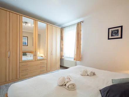 Das Schlafzimmer mit Doppelbett und Kleiderschrank