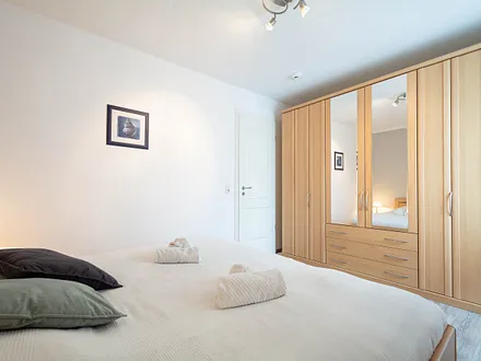 Das Schlafzimmer mit Doppelbett und Kleiderschrank