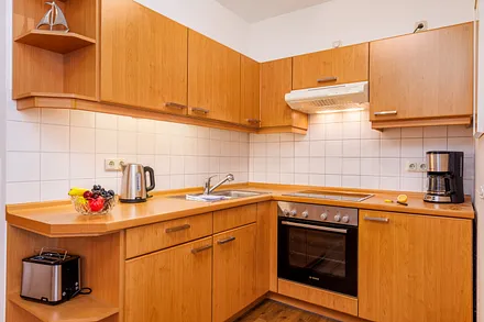 Die Küchenzeile mit Backofen, Cerankochfeld, Kühlschrank mit Eisfach etc. 