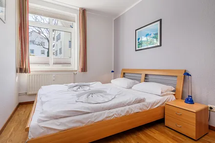 ... sowie einen Kleiderschrank, ein Doppelbett und Gardinen und Sichtschutzplissees am Fenster.