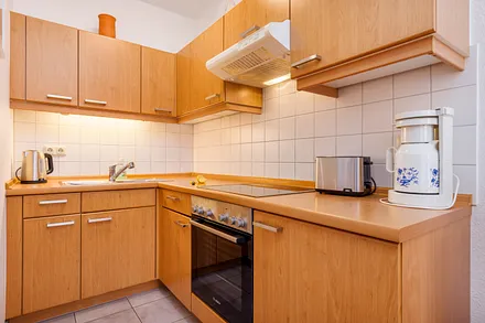 Die Küchenzeile mit Backofen, Kühlschrank mit Eisfach, Cerankochfeld etc.