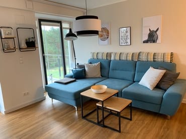 offener Wohnbereich mit Couch, Couchtisch und Stehlampe