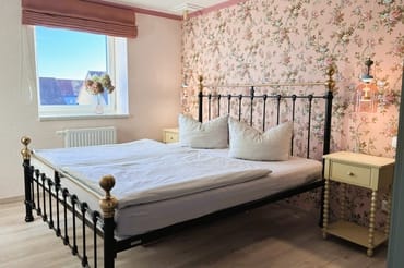 Das Schlafzimmer mit romantischen Tapeten ...