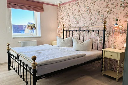 Das Schlafzimmer mit romantischen Tapeten ...