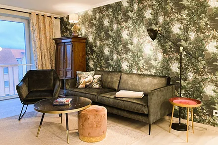 Das kuschelge Wohnzimmer mit zauberhaften Tapeten und opulenter Möblierung.