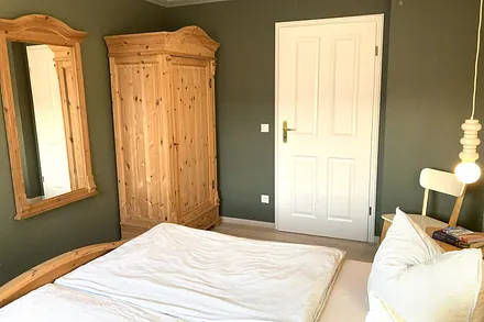 Das Schlafzimmer mit Kleiderschrank und großem Spiegel.