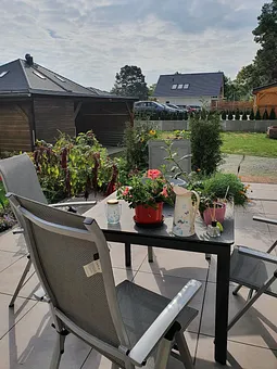 Terrasse mit Grill, Sitzecke, Gartenliegen und Wäschespinne