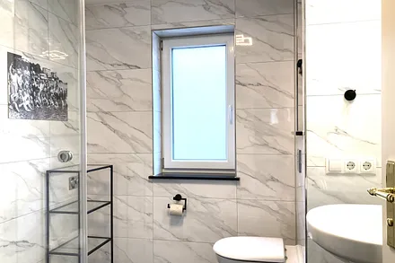 Das moderne Tageslichtbad bietet ein Fenster, eine Echtglasdusche ...