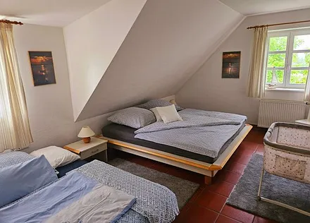 großzügiges Schlafzimmer mit Babyreisebett