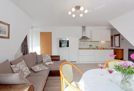 Wohnzimmer mit Esstisch und Küchenzeile
