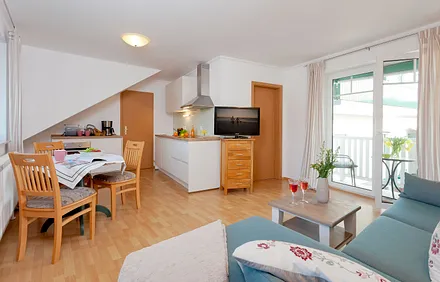 Wohnzimmer mit Esstisch und Küchenzeile