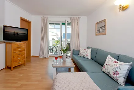 Wohnzimmer mit Esstisch und Küchenzeile