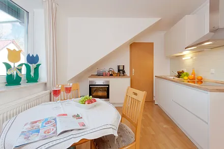 Wohnzimmer mit Esstisch und Küchenzeile