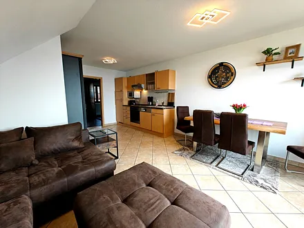 Wohnzimmer mit Esstisch und Küchenzeile