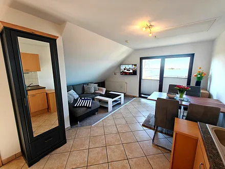 Wohnzimmer mit gemütlicher Couchgarnitur, Esstisch und Küchenzeile