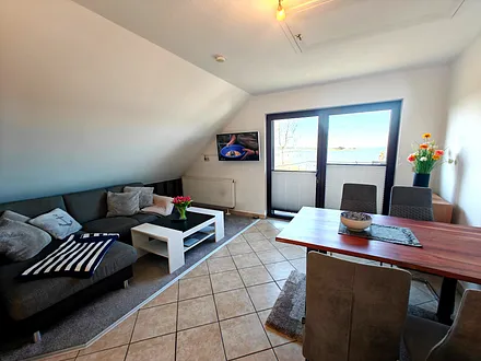 Wohnzimmer mit gemütlicher Couchgarnitur, Esstisch und Küchenzeile