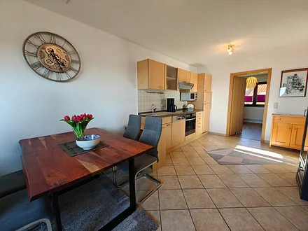 Wohnzimmer mit gemütlicher Couchgarnitur, Esstisch und Küchenzeile