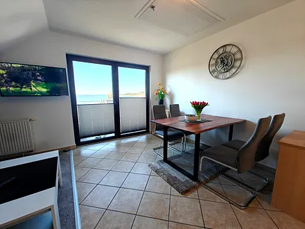 Wohnzimmer mit gemütlicher Couchgarnitur, Esstisch und Küchenzeile