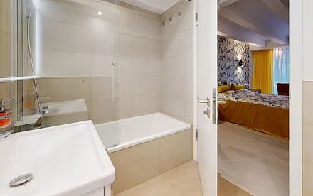 Bad en Suite mit Badewanne und Duschwand