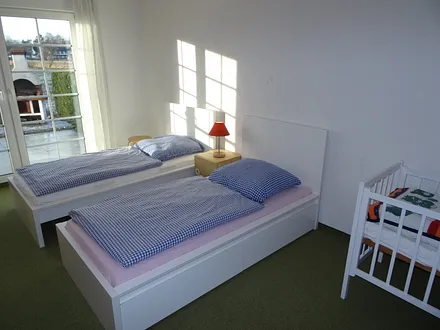 Schlafzimmer 2 mit zwei Einzelbetten und Kindenbett