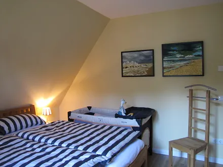 Schlafzimmer mit Doppelbet und Babybett