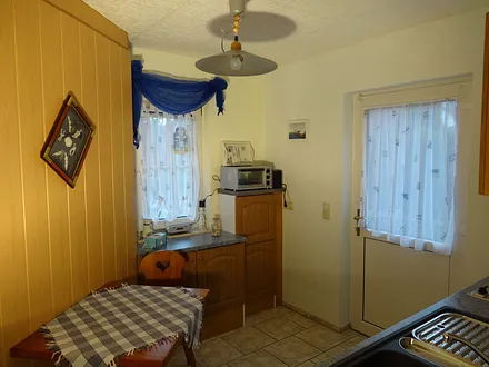 Kleine Küche mit Tisch und zwei Stühlen, Minibackofen, Toaster, Radio, ...