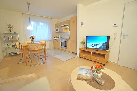 Wohnzimmer mit Esstisch und Küchenzeile