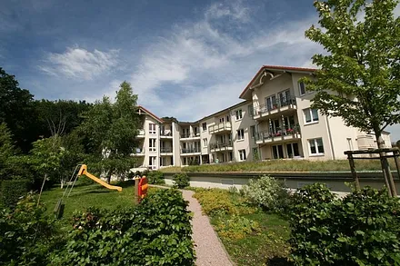 hintere Seite mit Grünanlage, im Hintergrund ist schon der angrenzente Küstenwald zu sehen, man geht ca. 250 m durch den parkähnlich angelegten Wald zum Strand