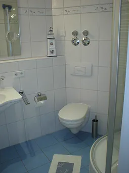 Ein maritim gestaltetes Bad mit Dusche und Fußbodenheizung gehört zum Appartment. 