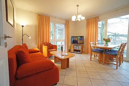 Wohnzimmer mit Schlafcouch, Esstisch und Fernseher