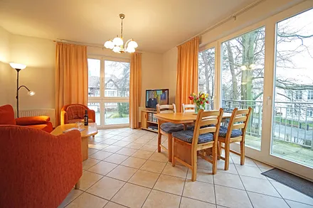 Wohnzimmer mit Schlafcouch, Esstisch und Fernseher