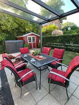 Sonnenterrasse im umzäunten Garten und Gartenhaus für Sonnenliegen und Fahrräder