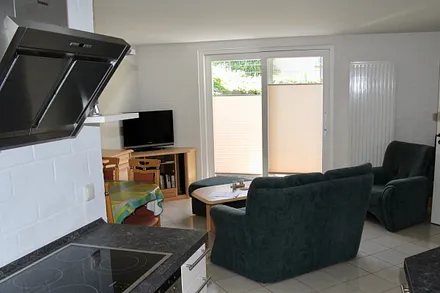 Blick von der Küchenzeile in das Wohnzimmer mit Terassentür 