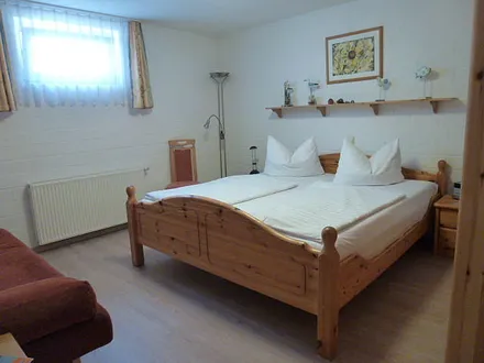 Schlafzimmer mit Doppelbett und Couch 