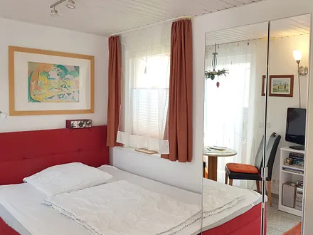 Heller Wohnraum mit zwei Terrassentüren und einem Fenster, komfortables Boxspringbett in der Größe 1,60x2m