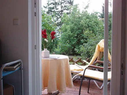 Blick vom Wohnzimmer auf die Terrasse und den Garten, der Bungalow ist vor allem auch wegen der Lage die ideale Unterkunft für Alleinreisende