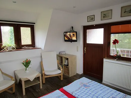 Wohn-Schlafraum mit Sitzecke und Tür zum Balkon