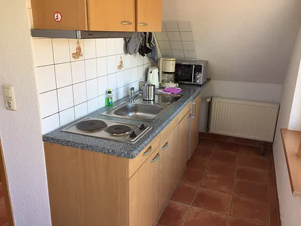 ....und helle Küchenzeile mit Herd,Abluft und Kühlschrank