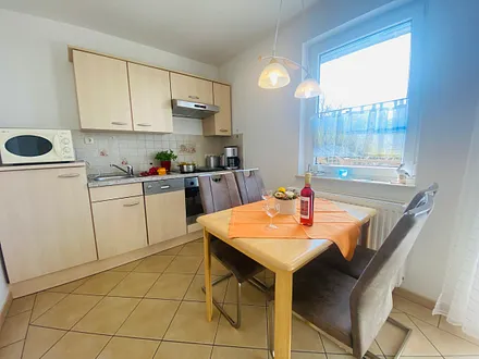 Essecke mit komplett ausgestatteter Küchenzeile (z.B. Backofen, Geschirrspüler, Mikrowelle, Kühlschrank mit Gefrierfach, Geschirr usw.)