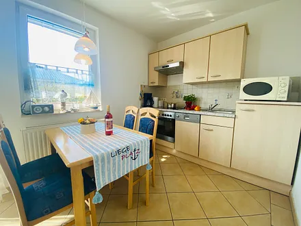 Essplatz mit komplett ausgestatteter Küchenzeile (z.B. Backofen, Geschirrspüler, Mikrowelle, Kühlschrank mit Gefrierfach usw.)