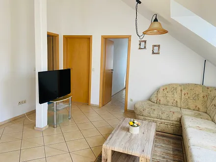 Wohnraum mit gemütlicher Polsterecke und Essplatz, Blick in das angrenzende separateKinderzimmer