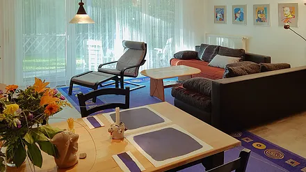 Wohnzimmer mit Sitzgruppe / Doppelbettcouch / Esstisch im Vordergrund