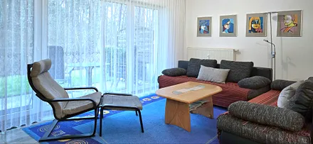 Wohnzimmer mit Sitzgruppe / Doppelbettcouch / Blick auf die Terrasse