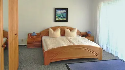 Schlafzimmer mit Fenster zum Wald