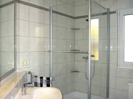 Bad mit Dusche und großem Spiegel