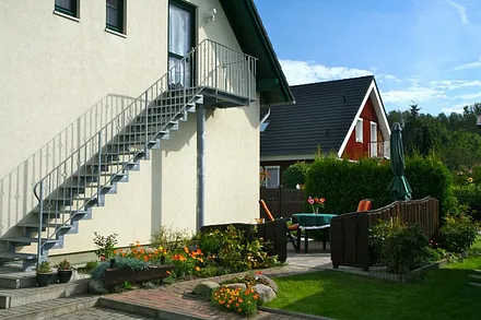 Sie sehen den Eingang zur Ferienwohnung, ihren Parkplatz, ihre Terrasse und den Fahrradunterstellraum.