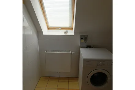 Duschbad mit Waschmaschine und Fenster