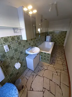 Bad mit Wanne und Duschrollo