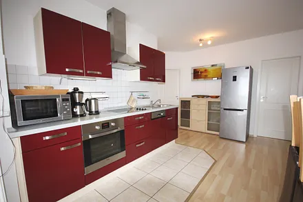 Küchenzeile mit Backofen und großem Kühlschrank mit Tiefkühlunterteil